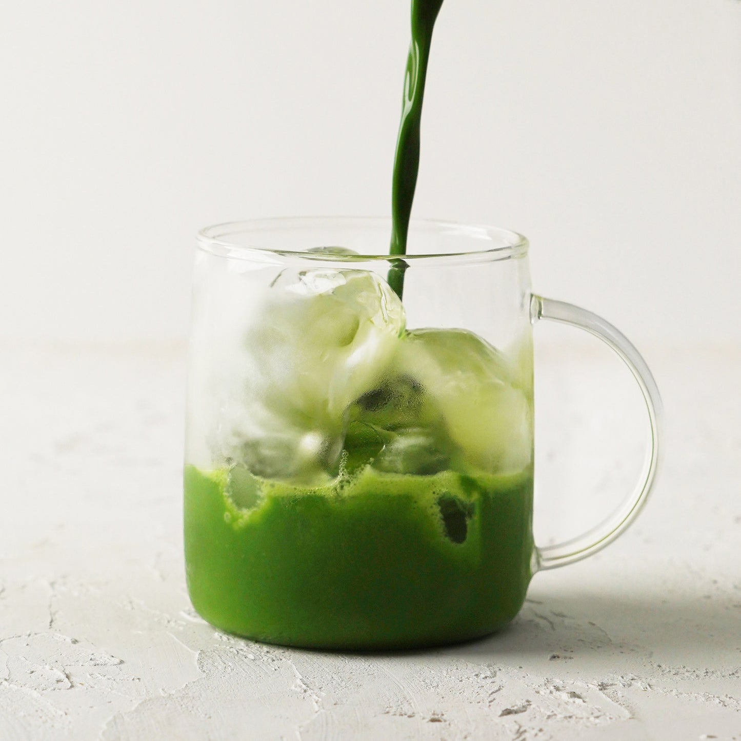 Nakamura Tokichi Uji Matcha Mix cha poured into a glass cup filled with ice